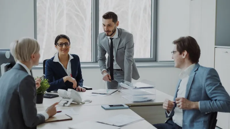 A team of consultants in discussion around a desk
